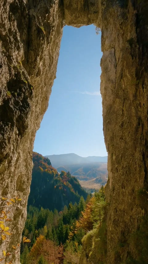 Vertical View through natural rock window in autumn mountains nature Stock Footage 299273507
