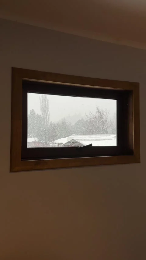 Vertical View Through Wooden Window Frame Showing Snowfall Outside in Melipeuco Stock Footage 346787583