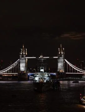 Vertical view of Tower Bridge lit at night over the dark River Thames, London Stock Photos