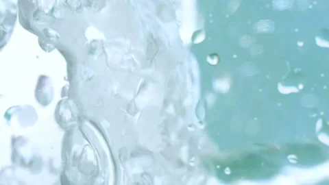 Vertical view of transparent bubbly Water on turquoise background slow motion Stock Footage 140729873