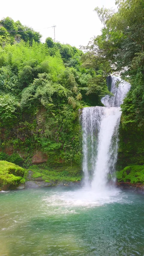 Vertical view of two-tiered Jion Falls cascading into emerald green basin 動画素材 341806350