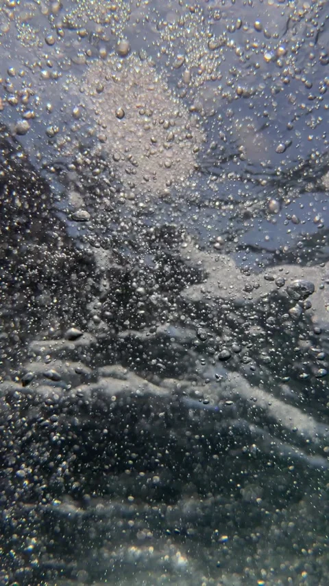 Vertical view of underwater air bubbles and tiny particles drifting through seaw Stock Footage 340150162