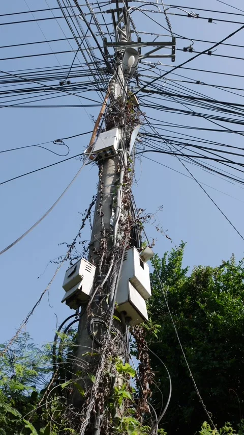 Vertical view of a utility pole carrying multiple overhead electric wires 動画素材 332416678