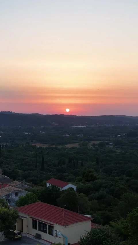 Vertical View of a Vibrant Sunset Over Agioi Douloi Village in Corfu Greece Stock Footage 340864145
