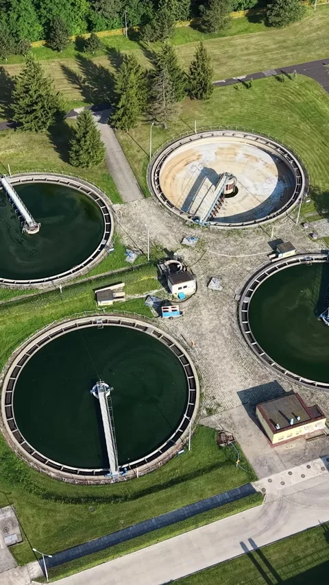 Vertical view. Wastewater processing plant with circular tanks and industrial Stock Footage 348631081