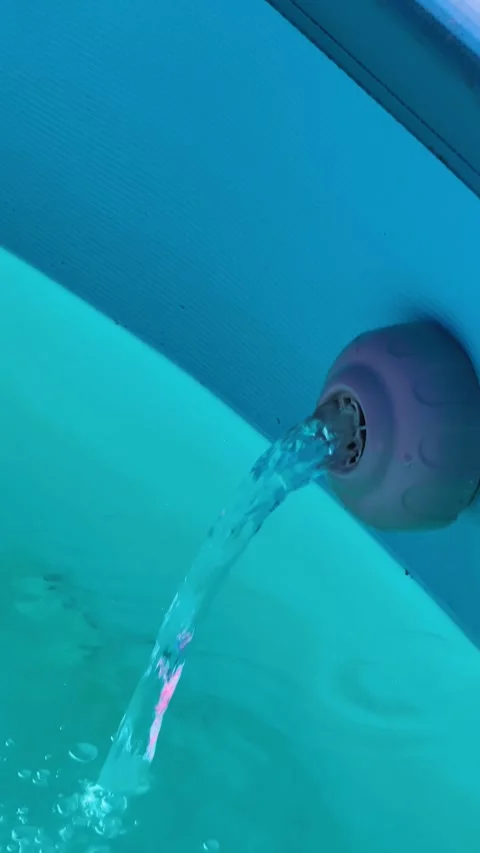 Vertical view of a Water Flowing From a Pump Into a Swimming Pool Stock Footage 345599611