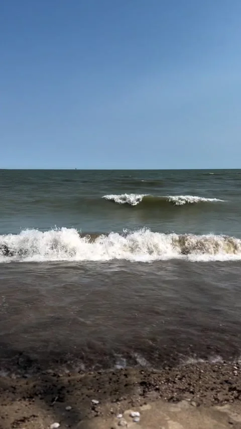 Vertical view of waves on the beach at noon time Stock Footage 238490044