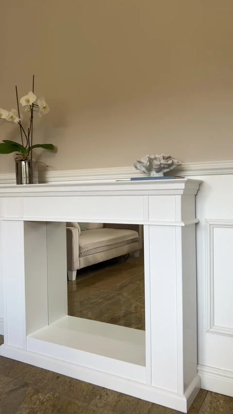 Vertical view of white handcrafted wooden fireplace mantle with mirror 動画素材 342954062
