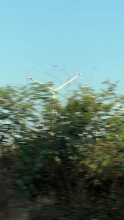 Vertical view of wind turbines rotating on a hillside landscape recorded from Stock Footage 331445919