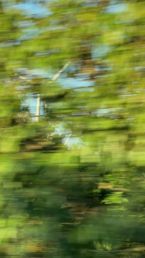 Vertical view of wind turbines rotating on elevated terrain recorded from moving Stock Footage 336236555