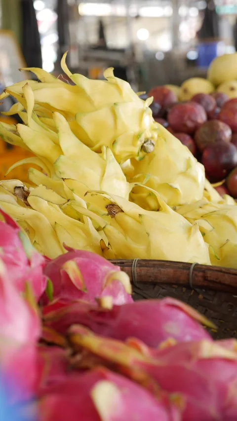 Vertical view of yellow and red dragon fruit displayed at a tropical fruit stall 動画素材 331866251
