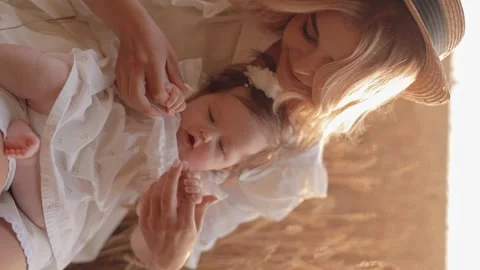 Vertical view of a young happy Caucasian woman holding a lovely little girl Stock Footage 247989059