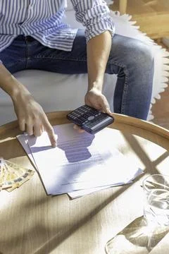 Vertical view of young man making calculations about the contract and how muc 스톡 사진