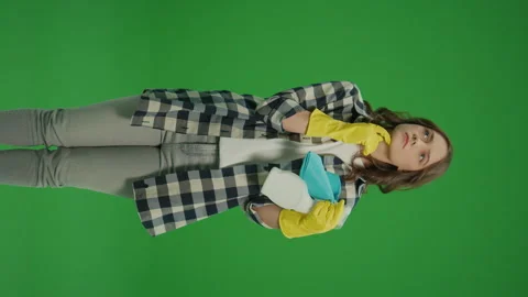 Vertical View.Green Screen.A Thoughtful Young Woman with Rag and Cleaning Spray. Stock Footage 249415805