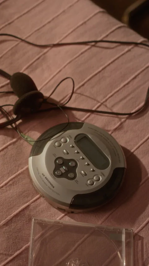 Vertical of Vintage Portable Cd Player with Headphones Resting on Fabric Stock Footage 343640120