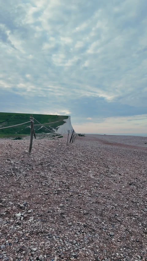 Vertical walking view on calm pebble beach with wooden groynes Stock Footage 309768635