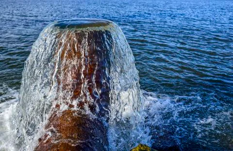 Vertical water flow from the pipe to the fish pond Stock Photos
