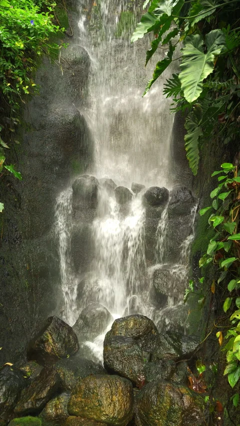 Vertical - A waterfall, cascading onto large stones or boulders. Stock Footage 288099285
