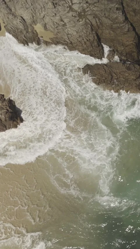 Vertical Waves Roling on to Rocks and Beach Stock Footage 285650156