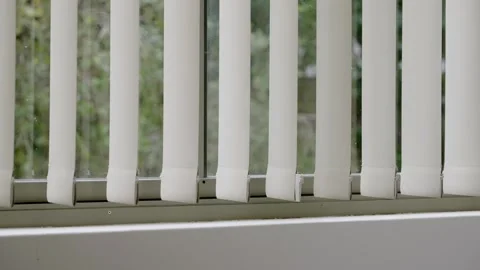 Vertical white black out window blinds or shades moving slowly inside room Stock Footage 287301369