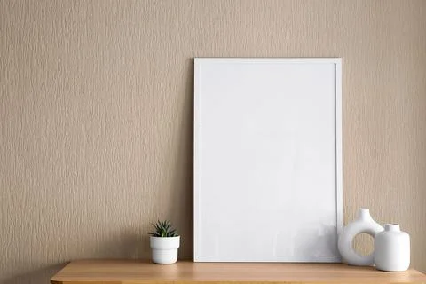 Vertical white picture frame mockup on a wooden table with a succulent plant  Stock Photos