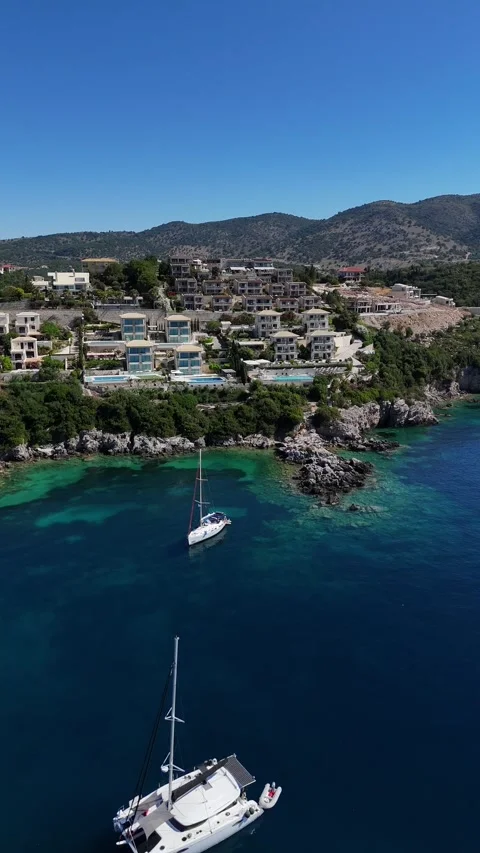 Vertical wide angle drone 4K view of green island coastline and tourist bay in G Stock Footage 340560359