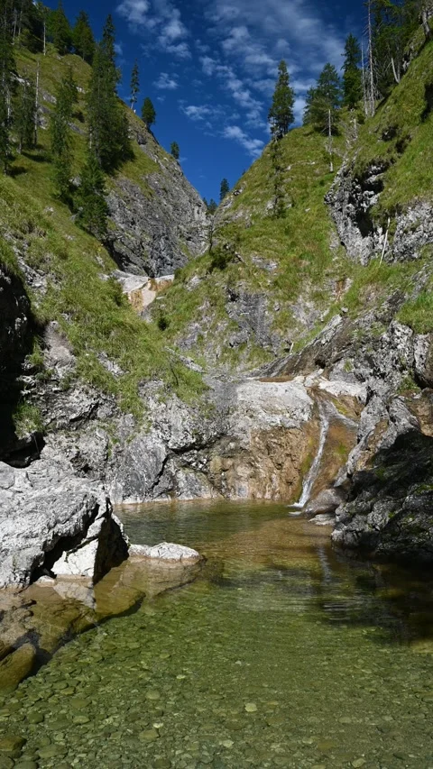 Vertical wideangle shot of a mountain stream in between steep mountains Stock-Footage 260893924