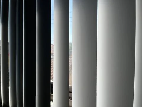 Vertical window blinds filtering soft sunlight Stock Photos