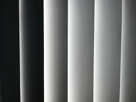 Vertical window blinds filtering soft sunlight Stock Photos