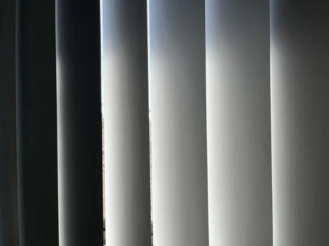 Vertical window blinds filtering soft sunlight Stock Photos