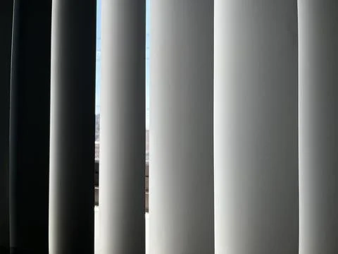 Vertical window blinds filtering soft sunlight Stock Photos