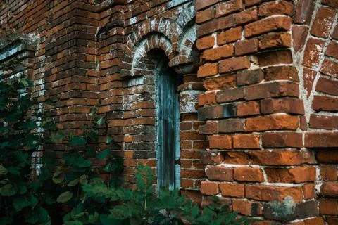 A vertical window in a brick stable. 19th century buildings. Stock Photos