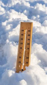 Vertical Winter background full of snow. Thermometer on snow shows low temper Stock Photos