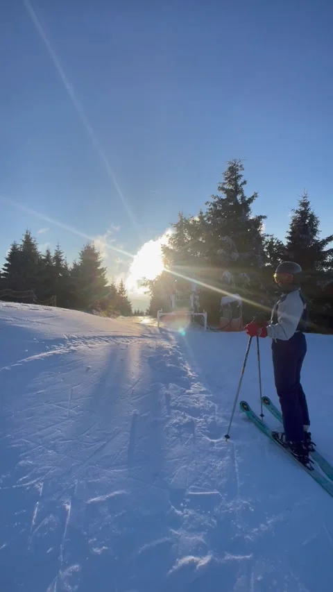 Vertical winter sun over snowy ski slope with frosted pine trees Stock Footage 325647371