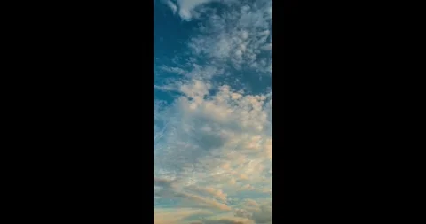 Vertical wispy cirrus and cumulus clouds in sunset sky time lapse Video stock 340772250