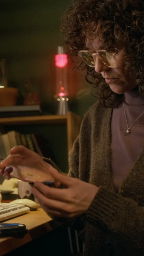 Vertical of Woman Checking out CD Disks while Working on Retro Computer Video stock 327239526