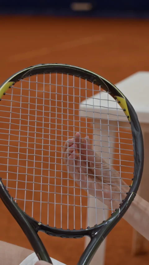 Vertical of Woman Checking Strings of Tennis Racket before Match on Clay Court Video stock 317994981