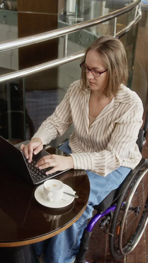 Vertical of Woman with Disability Working Remotely on Laptop in Cafe Stock Footage 343782258