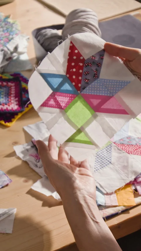 Vertical of Woman Holding Handmade Patchwork Quilt Block during Sewing Class Stock Footage 341939411