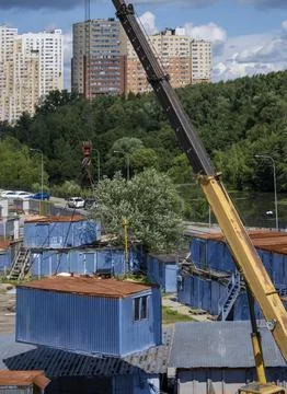 Vertical yellow crane moving construction trailer to another place Foto stock