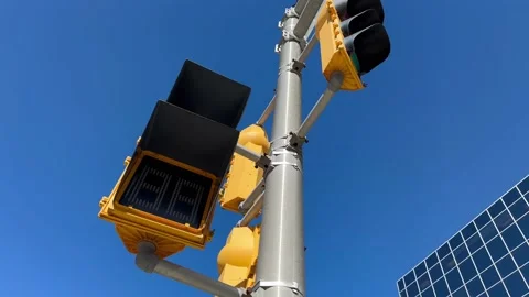 Vertical yellow traffic light with blue sky and skyscraper in the background. Stock Footage 238532755