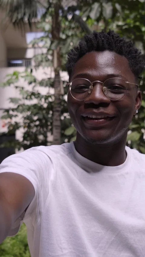 Vertical young African American smiling and cheerful young man talking to camera Stock Footage 239106234