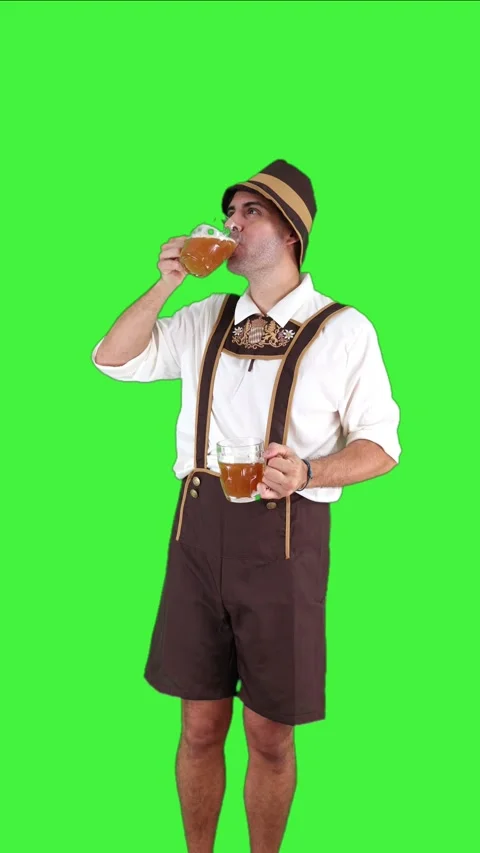 Vertical young bavarian man drinking two beer glasses in traditional attire.. Stock Footage 281192367