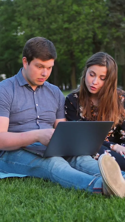 Vertical of Young Beautiful Couple Looking at Laptop and Laughing Stock Footage 278485089