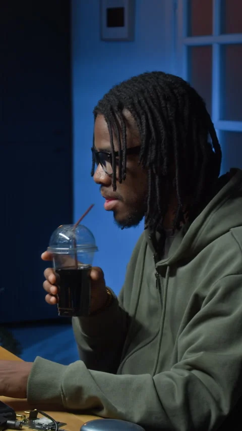 Vertical of Young Black Coder Drinking Soda while Hacking System in Home Office Vidéo 328286344