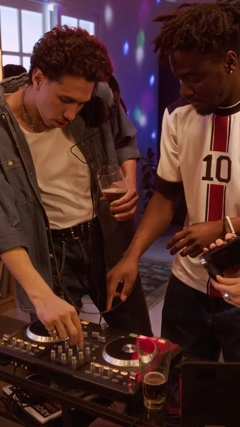 Vertical of Young Black Man Showing DJ Controller to Friend at Home Party Stock Footage 332066067