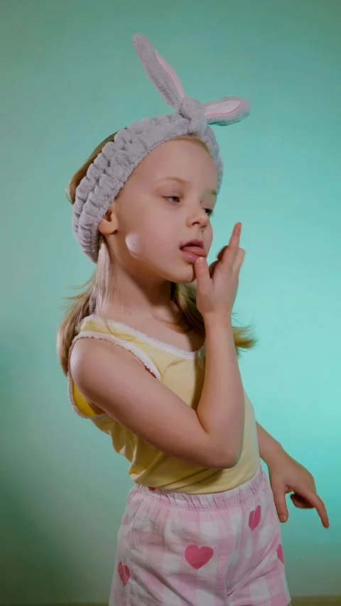 Vertical. Young child with bunny ears headband singing and dancing funny against Stock Footage 323373860