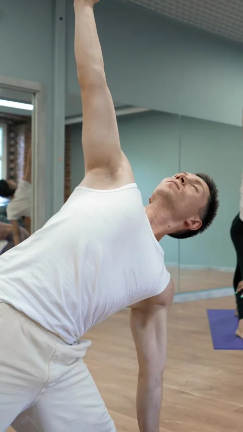 Vertical of Young coach conducts classes of yoga showing pose for women Stock Footage 275623033