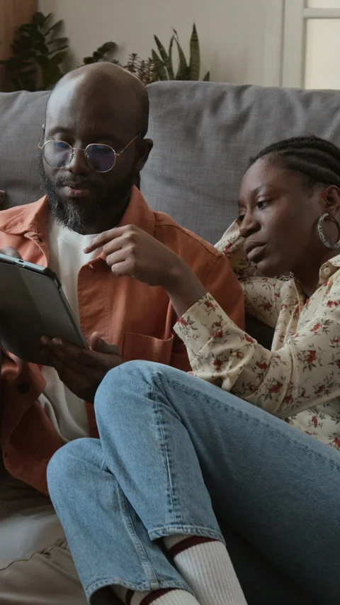 Vertical of Young Couple Researching Flight Options on Tablet to Go on Holiday Stock Footage 333293231