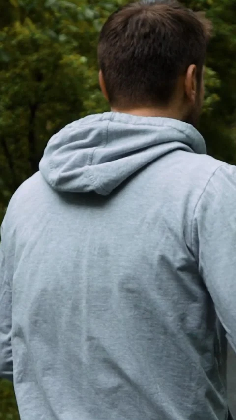 Vertical of Young handsome runner outside in autumn nature park with phone Stock Footage 278481517